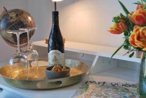 una botella de vino y un tazón de pasta sobre una mesa en Les Hauts d'Avignon, en Rochefort-du-Gard