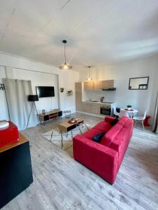 een woonkamer met een rode bank en een tafel bij Escale Confort in Montlhéry