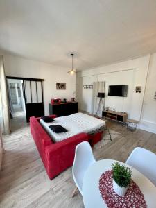 een woonkamer met een rode bank en een bed bij Escale Confort in Montlhéry