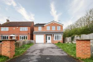 a red brick house with a white garage at Delightful House with Garden in Sherburn in Elmet