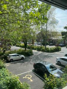 een parkeerplaats met auto's geparkeerd op een parkeerplaats bij Contemporary Duplex: Private Patio, Secure Parking in Stockport