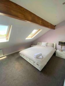 a bedroom with a bed with two skylights at Contemporary Duplex: Private Patio, Secure Parking in Stockport