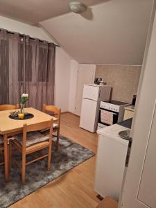 uma cozinha e sala de jantar com mesa e cadeiras em APARTMAN ŽELJA em Sremska Mitrovica