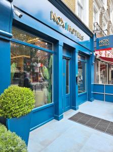 uma loja azul em frente a uma loja das indústrias ny em NOX Hyde Park em Londres