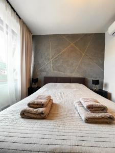 a bedroom with a bed with two towels on it at Stylowy Apartament w Serocku in Serock