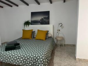 1 dormitorio con 1 cama con almohadas amarillas y negras en YucaJaus en Teguise
