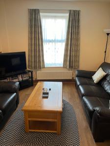 uma sala de estar com um sofá e uma mesa de centro em A Family Cottage in Tenby em Tenby