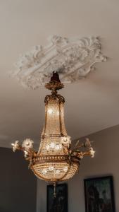 een kroonluchter aan een plafond in een kamer bij Hôtel l'Abbaye in Saint-Cyprien