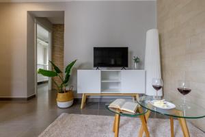 a living room with a tv and a table with wine glasses at Málaga Dream Apartment in Málaga