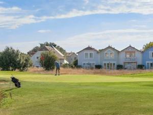 un homme debout sur un parcours de golf avec un chien dans l'établissement Appartement, vue imprenable sur port, à Talmont-Saint-Hilaire