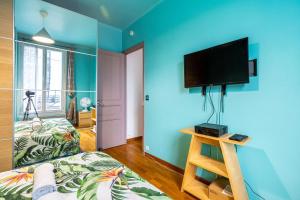 Camera blu con letto e TV a parete di GuestReady - Memorable stay in the suburbs a Issy-les-Moulineaux