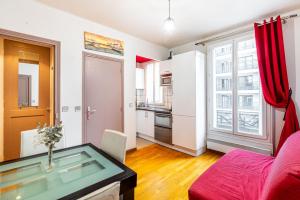 a living room with a red couch and a glass table at GuestReady - Memorable stay in the suburbs in Issy-les-Moulineaux