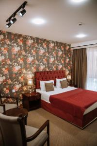 Address Boutique Hotel Baku في باكو: غرفة نوم بسرير كبير وورق جدران