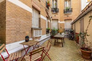 an outdoor patio with tables and chairs on a building at GuestReady - Cozy Apt Near Square Louise Michel in Paris