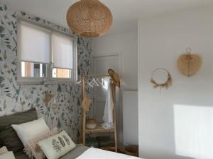 1 dormitorio con cama, ventana y espejo en Le Refuge du Lac, en Chaumousey