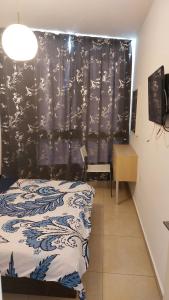 1 dormitorio con 1 cama con cortina azul y blanca en Suite on the Bat Yam seashore, en Bat Yam