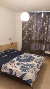 um quarto com uma cama com um cobertor azul e branco em Suite on the Bat Yam seashore em Bat Yam