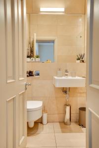 a bathroom with a toilet and a sink at Spence Lodge: Beautiful 2-Bedroom Stone Cottage in Alnmouth