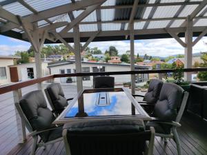 d'une terrasse avec une table en verre et des chaises. dans l'établissement Altair Motel, à Cooma