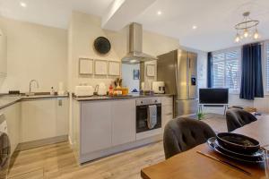 a large kitchen with a table and chairs in it at The Apartment by Palerose - Cosy, business traveller friendly, with free parking in Farnborough