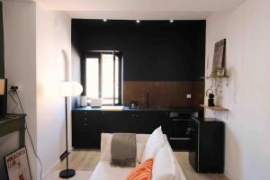 Il comprend un salon avec un mur noir et une cuisine. dans l'établissement Le 23, cocon dans le centre historique, à Montauban 14 autres photos