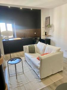 un salon avec un canapé blanc et une table dans l'établissement Le 23, cocon dans le centre historique, à Montauban