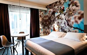 卡薩萊蒙費拉托的住宿－商務酒店，一间卧室配有一张带花墙的床