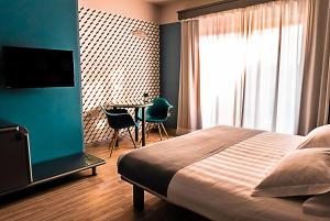 - une chambre avec un lit et une table avec des chaises dans l'établissement Business Hotel, à Casale Monferrato