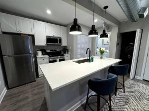 uma cozinha com um balcão branco e um lavatório em West Loop King Oasis/2BR that sleeps 6 guests/walk to Fulton Market em Chicago