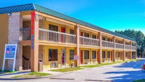 un grand bâtiment jaune sur le côté d'une rue dans l'établissement Mayfair Inn, à Williamston