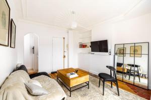 ein Wohnzimmer mit einem Sofa und einem Tisch in der Unterkunft GuestReady - Parisian getaway near Louvre Museum in Paris