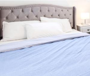 - un lit avec des draps bleus et des oreillers blancs dans l'établissement New Luxury Suite 6Mins To Falls, Free Parking, à Niagara Falls