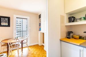 a kitchen and dining room with a table and chairs at GuestReady - Peaceful Haven in the 14th arr. in Paris