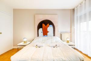 ein Schlafzimmer mit einem großen Bett mit einem großen Kopfteil in der Unterkunft GuestReady - Peaceful Haven in the 14th arr. in Paris