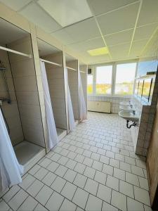 a large bathroom with two sinks and a shower at H1 Herberge-One Erfurt in Erfurt