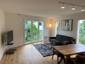 uma sala de estar com um sofá e uma mesa em Modern one bedroom flat close to the city - Bass1 em Bassersdorf