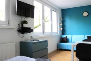 a blue room with a blue couch and a window at Labo Apartment Karmelicka in Warsaw