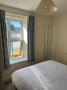 um quarto com uma cama e uma janela em A Family Cottage in Tenby em Tenby