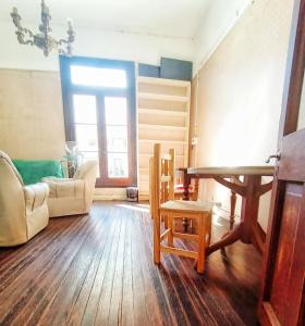 a living room with a table and a chair at En La Plata Hostel El Pampa in La Plata