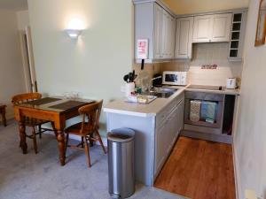 a small kitchen with a table and a counter top at The Uplands Apartments in Saint Helier Jersey