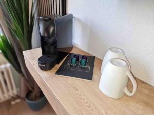 einen Tisch mit einem Buch, einem Lautsprecher und einer Vase in der Unterkunft Cozy Apartment Wi-Fi in Fellbach