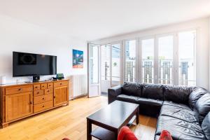a living room with a couch and a tv at GuestReady - Comfort near Parc Clichy-Batignolles in Paris