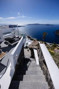 een trap naar een huis met uitzicht op de oceaan bij Nevma Suites in Firostefani