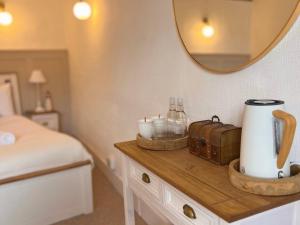 a bedroom with a bed and a table with a mirror at Black Buoy Inn in Wivenhoe