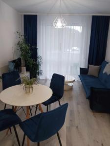 sala de estar con mesa, sillas y sofá en Apartament MajaHouse, en Nowa Sól