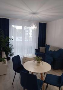 sala de estar con sofá, mesa y sillas en Apartament MajaHouse, en Nowa Sól