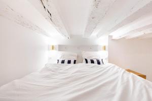 a bedroom with a large white bed with two pillows at GuestReady: Designer Studio in the heart of Marais in Paris