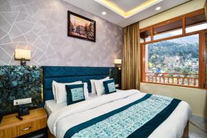 a hotel room with a bed and a window at Hotel Pawan Regency in McLeod Ganj
