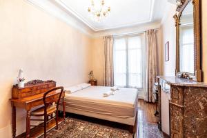 a bedroom with a bed and a desk and a sink at GuestReady - Charming classic near Montparnasse in Paris