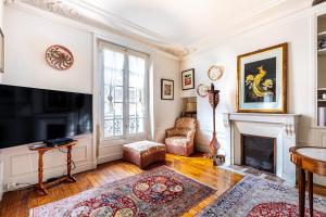 a living room with a fireplace and a tv at GuestReady - Charming classic near Montparnasse in Paris